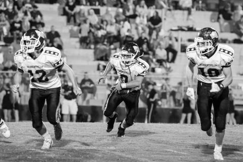 Brodie Porter (12) and Gage Alexander (10) protect Gage Key (7) as he advances the ball upfield for Hubbertville.