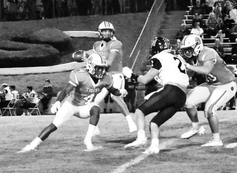 Langston Strawbridge (8) is shown dropping back to pass as Zac Jackson (4) and Jordan Feltman (50) block.