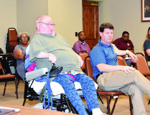 Samuel Matthews (seated in a wheelchair next to Pastor Scott Davis) was one of many at the public hearing who expressed the need for public transportation.