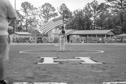 Barrett Afshar holds the flag for the National Anthem before the start of the games.