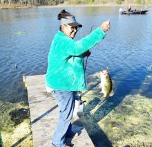 Angela Cobb is shown with one of the many bass she caught on opening day at the Fayette County Lake.